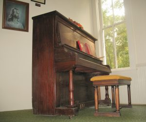 The old upright piano with the portrait of Jesus. 